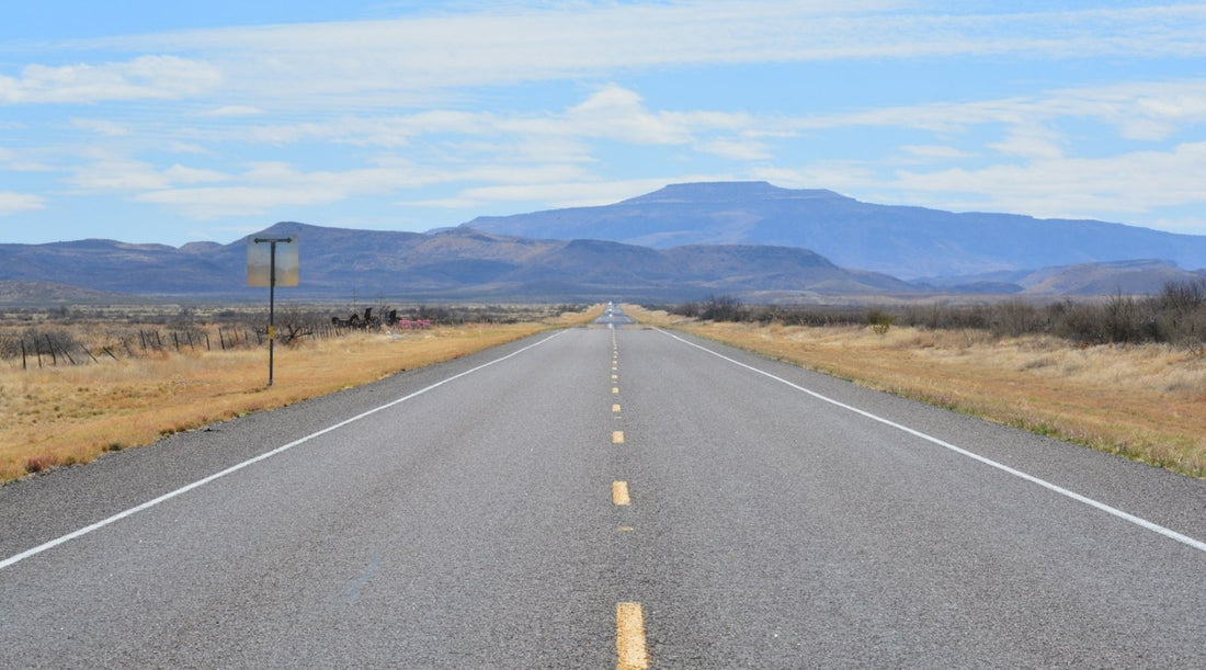 Scenic West Texas highway leading toward distant mountains on a Texas weekend road trip